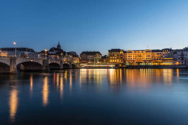Les quais du Rhin à Bâle, illuminés à la tombée de la nuit